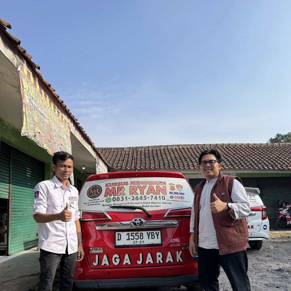 Seorang siswa dan instruktur berfoto di depan mobil MR RYAN.